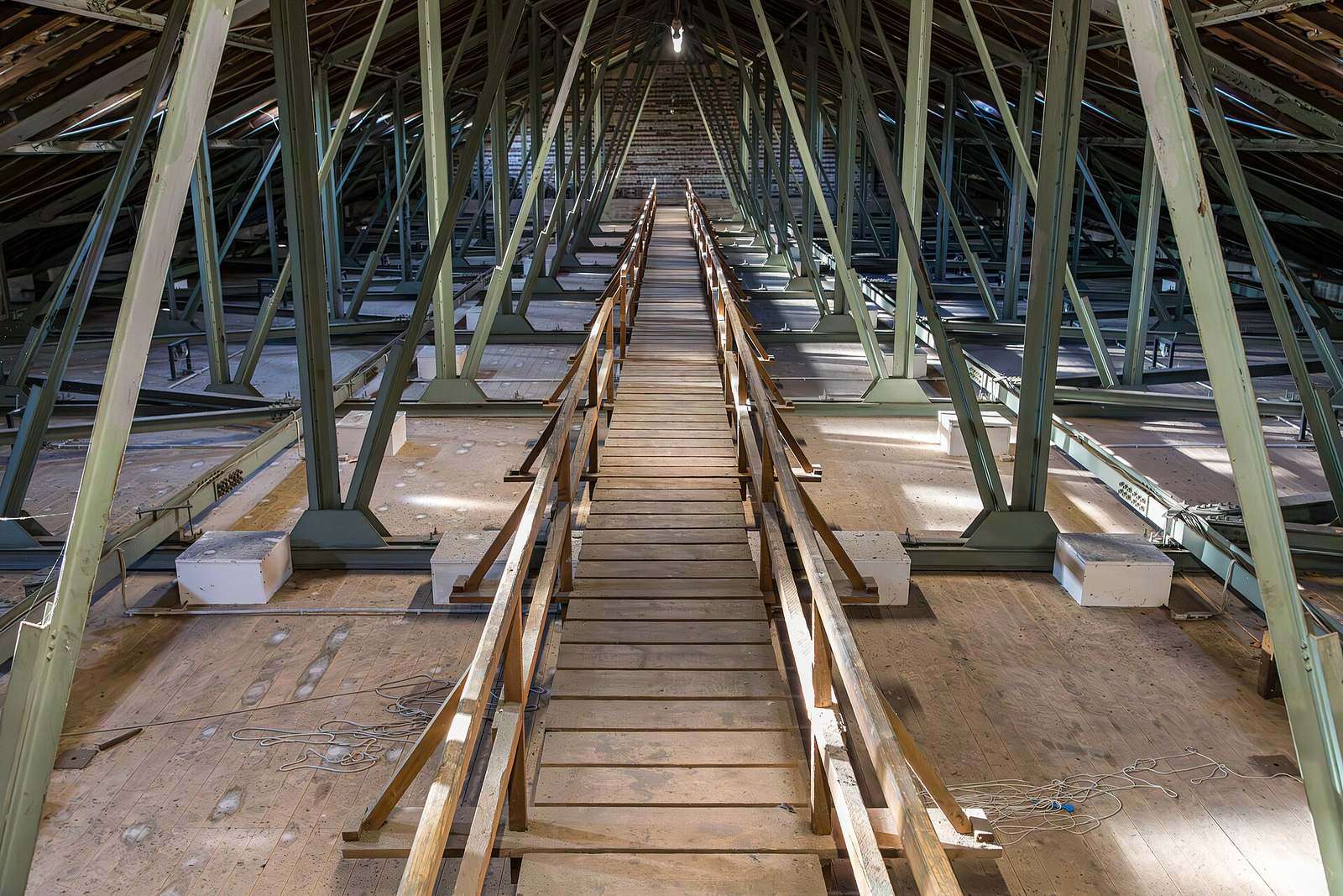 Houten dakgebinte van een grote zolder met een loopbrug in het midden
