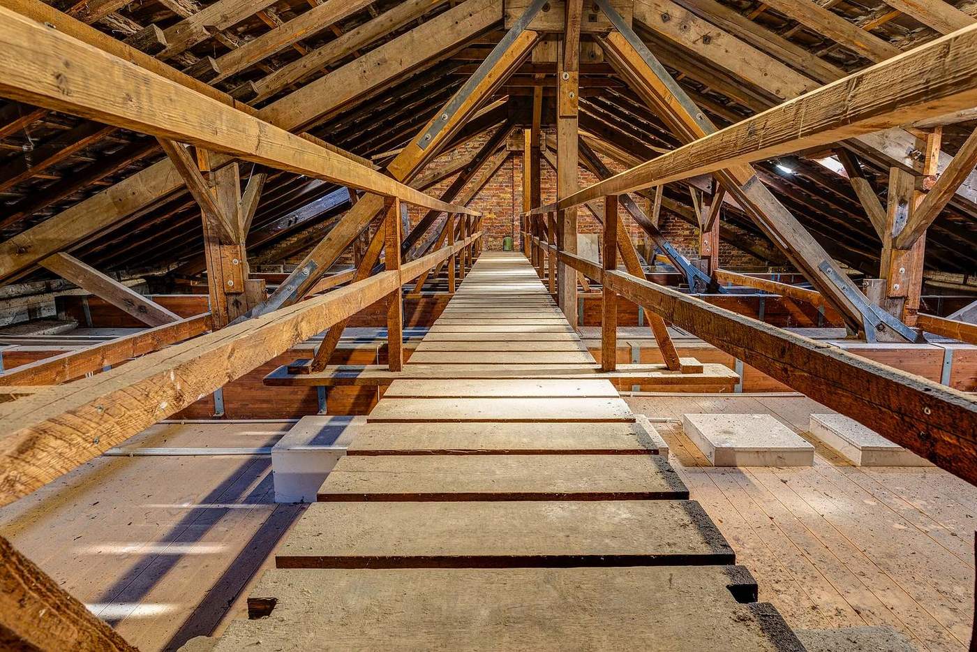Zolder onder een houten dakgebinte met schuine balken